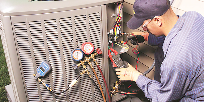 A technician checking thermometers for HVAC unit maintenance.