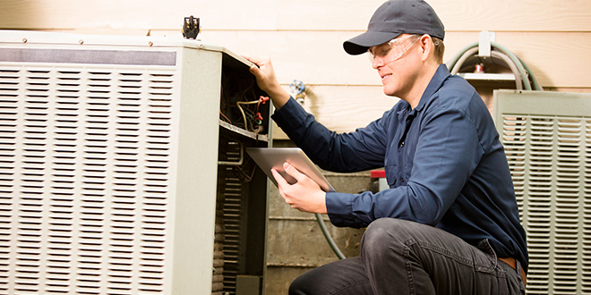 A technician checks the results after testing an HVAC unit.